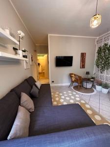 uma sala de estar com um sofá e uma televisão em Bon Bon del Viale-con posto auto privato em Asti
