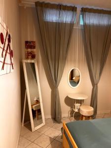 um quarto com um espelho e uma mesa e cortinas em Bon Bon del Viale-con posto auto privato em Asti