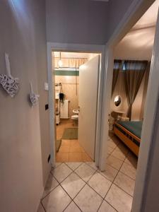 a hallway leading to a bathroom with a bed and a toilet at Bon Bon del Viale-con posto auto privato in Asti +18 photos
