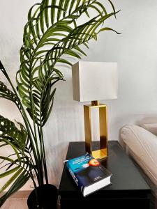 a lamp sitting on a table next to a plant at Palais 5min Luxury&Cinema Studio in Cannes