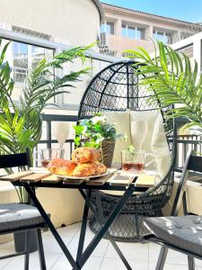 einen Tisch auf einem Balkon mit einem Teller Essen drauf in der Unterkunft Palais 5min Luxury&Cinema Studio in Cannes