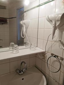 ein Bad mit einem Waschbecken und einem Spiegel in der Unterkunft Appart Hotel La Defense in Courbevoie