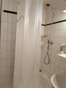 een badkamer met een douche met een wit douchegordijn bij Appart Hotel La Defense in Courbevoie