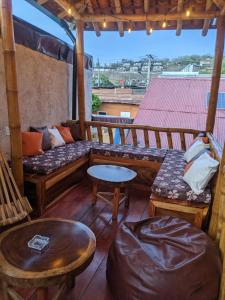 eine Veranda mit Sofas und Tischen auf dem Dach in der Unterkunft Chale's House Hotel in San Juan del Sur