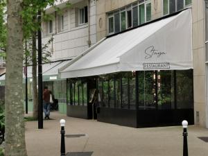een winkel met luifel voor een gebouw bij Appart Hotel La Defense in Courbevoie