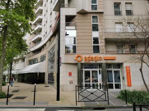 ein Gebäude mit einem orangenen Schild an der Seite in der Unterkunft Appart Hotel La Defense in Courbevoie