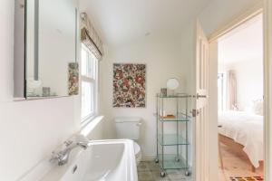 a bathroom with a sink and a toilet and a bed at Bowden Wood in Dartmouth
