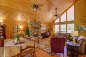 a living room with a fireplace in a log house at Roomy Riverfront Trout Valley Cabin with Porch! in Mountain View +32 photos