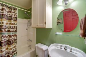 a bathroom with a sink and a red door on the wall at Roomy Riverfront Trout Valley Cabin with Porch! in Mountain View