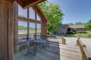 een houten terras met een tafel en stoelen op een huis bij Roomy Riverfront Trout Valley Cabin with Porch! in Mountain View