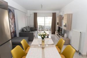 a living room with a table and yellow chairs at Fully equipped flat in Piraeus (Erm_C7) in Piraeus