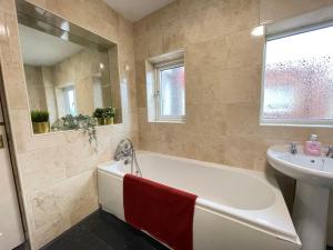 a bathroom with a white tub and a sink at The First Rho in Bishop Auckland