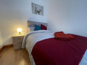 a bedroom with a large bed with a red blanket at The First Rho in Bishop Auckland