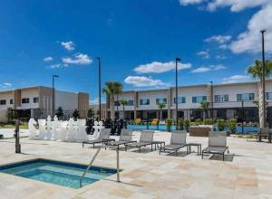 a courtyard with chairs and a pool in front of a building at Beautiful 4 suites - Close to Disney 7505 in Orlando