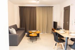 un soggiorno con divano e tavolo di Sandy feet comfort suite a Kardámaina