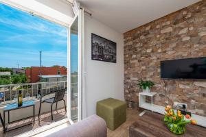 sala de estar con ventana grande y TV en Charming Apartment Ines, en Dubrovnik