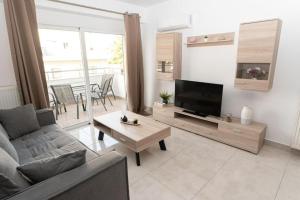 a living room with a couch and a tv and a table at Fully equipped flat in Piraeus (Erm_C7) in Piraeus