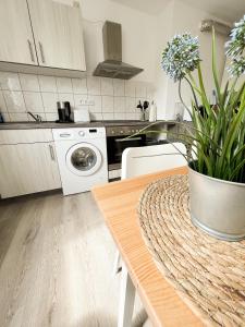 Exclusives Apartment in Toplage في فيلهلمسهافن: مطبخ مع طاولة مع وعاء من الزهور