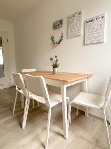 Exclusives Apartment in Toplage في فيلهلمسهافن: طاولة غرفة طعام بيضاء مع كراسي بيضاء