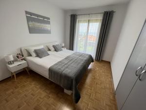 Un dormitorio con una cama grande y una ventana en Magnolia Apartments en Izola