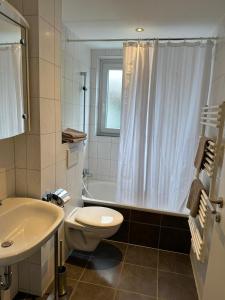 uma casa de banho com um WC, uma banheira e um lavatório. em Steinweg 7 Ferienwohnung em Kassel
