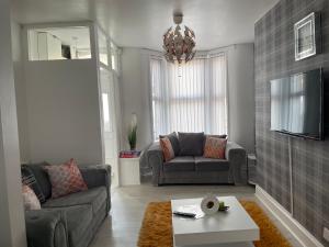 a living room with two couches and a tv at Luxury Spacious 2 Bedroom Home. in Liverpool