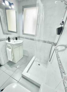 a white bathroom with a toilet and a sink at Apartamento primera línea Altea in Altea