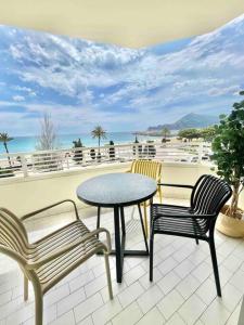 two chairs and a table on a patio with a view of the ocean at Apartamento primera línea Altea in Altea