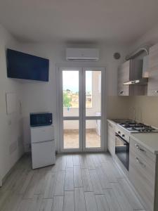 uma cozinha com uma grande janela e um fogão forno superior em Civico 14 Apartment 2 em Monserrato