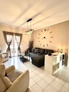 a living room with a couch and a clock on the wall at Ven Luxury Apartment in Zakynthos