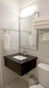 y baño con lavabo, espejo y aseo. en Arena Condominium Aruba en Palm-Eagle Beach