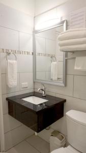 a bathroom with a sink and a mirror and a toilet at Arena Condominium Aruba in Palm-Eagle Beach