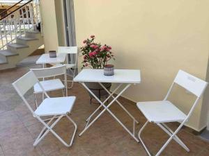 a white table and chairs with flowers on it at NG Luxury Apartments at Nea Kallikrateia No 1 in Nea Kalikratia