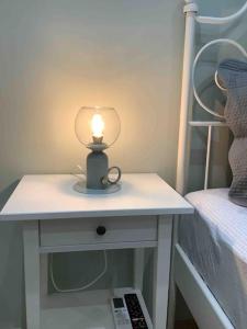 a lamp sitting on a table next to a bed at NG Luxury Apartments at Nea Kallikrateia No 1 in Nea Kalikratia