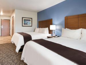 two beds in a hotel room with blue walls at My Place Hotel-Wixom/Novi/Detroit, MI in Wixom