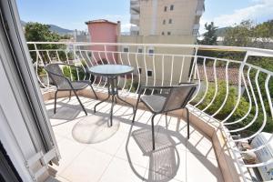 a balcony with chairs and a table on a balcony at K&C Rooms- Apartments in Markopoulo