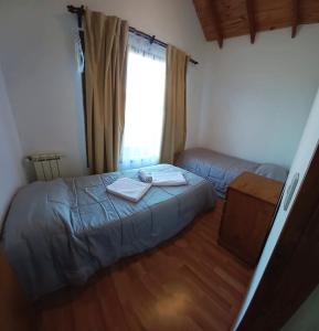 a small bedroom with a bed and a window at Alma de Maitén in San Carlos de Bariloche