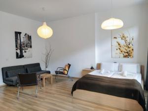 - une chambre avec un lit, une chaise et un canapé dans l'établissement StayBearlin Apartments Prenzlauer Berg Grellstraße, à Berlin