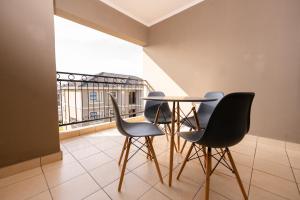 a table and chairs in a room with a balcony at Fully furnished apartment. in Sandton