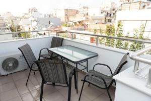 a balcony with a table and chairs on a building at Fully equipped flat in Piraeus (Erm_C7) in Piraeus