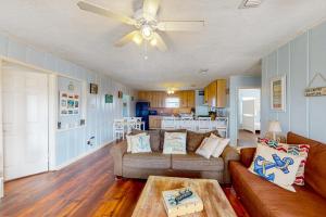 ein Wohnzimmer mit einem Sofa und einem Tisch in der Unterkunft Captain's Quarters in Galveston
