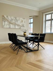 a dining room with a black table and chairs at Luxury Home / 3-Raum-Suite an der Frauenkirche / 6 in Dresden