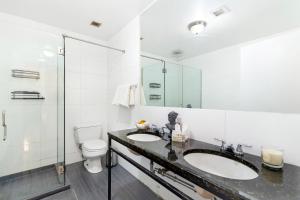 a white bathroom with two sinks and a toilet at Luxurious 3 BR SOHO in New York
