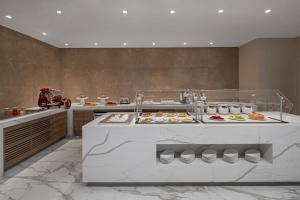 a kitchen with many different types of food on display at AC Hotel by Marriott Fort Lauderdale Sawgrass Mills Sunrise in Sunrise