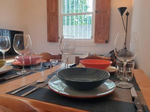 una mesa con un tazón y copas de vino. en Casita adosada, en Vigo