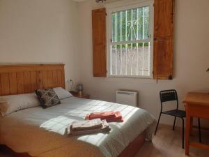 a bedroom with a bed with two towels on it at Casita adosada in Vigo