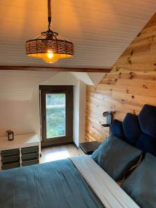 ein Schlafzimmer mit einem blauen Bett und einem Fenster in der Unterkunft Petit duplex cocooning in Férel