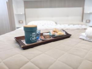 a tray of food and a cup of coffee on a bed at Country House Ortensie in Torre del Greco