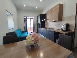 a kitchen with a table with a vase of flowers on it at Country House Ortensie in Torre del Greco +16 photos