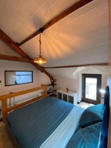 ein Schlafzimmer mit einem blauen Bett in einem Zimmer in der Unterkunft Petit duplex cocooning in Férel
